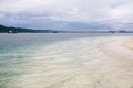 Scenic view of tropical beach with dramatic clouds in blue sky and mountain in background Royalty Free Stock Photo