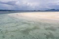 Scenic view of tropical beach with dramatic clouds in blue sky and mountain in background Royalty Free Stock Photo