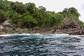 Scenic view of tropical rocky beach with trees foliage and cliff. Sea water wave and splash. For environment and geology. Royalty Free Stock Photo