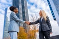 Scenic view of two multi-ethnic businesswomen greeting each other outside of the office