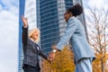 Scenic view of two multi-ethnic businesswomen greeting each other outside of the office