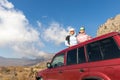 Scenic view two young adult woman friends enjoy having fun sit on car roof at adventure suv offroad mountain trip Royalty Free Stock Photo