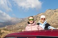 Scenic view two young adult woman friends enjoy having fun sit on car roof at adventure suv offroad mountain trip Royalty Free Stock Photo