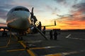 Scenic view of unrecognizable passengers silhouette boarding on airplane at sunset