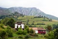Scenic view of valley in Asturias with traditional farm buildings and green meadows a foggy day