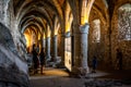 Scenic view of vaulted gothic dungeons and tourists looking at an information board in the underground of Chillon castle Royalty Free Stock Photo