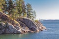 The scenic view of West Vancouver rocky shorelines with pine trees in Canada