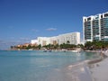 Scenic view of white hotels buildings on sandy beach at bay of Caribbean Sea in Cancun city in Mexico with tourists Royalty Free Stock Photo