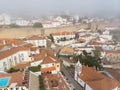 Scenic view of white houses red tiled roofs, and castle from wall of fortress with clouds. Obidos village, Portugal. Royalty Free Stock Photo