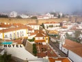 Scenic view of white houses red tiled roofs, and castle from wall of fortress with clouds. Obidos village, Portugal. Royalty Free Stock Photo