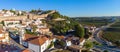 Scenic view of white houses red tiled roofs, and vineyard castle from wall of fortress. Obidos village, Portugal. Royalty Free Stock Photo