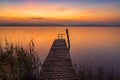 Scenic view of a wooden pier by the shore of a lake with beautiful twilight visible on the horizon Royalty Free Stock Photo