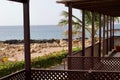 Scenic view of a wooden porch on the beach with palm trees on a sunny day Royalty Free Stock Photo