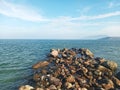 Scenic White Sand Beach with Wavy Water and Clear Blue Sky Background, Beautiful Seashore View with Mountains and stones in Summer Royalty Free Stock Photo