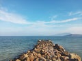 Scenic White Sand Beach with Wavy Water and Clear Blue Sky Background, Beautiful Seashore View with Mountains and stones in Summer Royalty Free Stock Photo