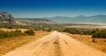 winding gravel road with a view of a lonely rocky mountain in the countryside area in Turkey. Burdur lake at the background Royalty Free Stock Photo