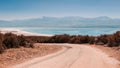 winding gravel road with a view of a lonely rocky mountain in the countryside area in Turkey. Burdur lake at the background Royalty Free Stock Photo