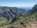 Sceniic landscape at hiking trail through Barranco de Guarimiar Gorge. Green mountain canyon slopes with palm trees and