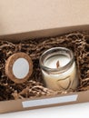 Scented candle in a glass jar in an open corton box