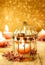 Scented candle in vintage birdcage. Golden background