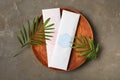 Scented sachets and green leaves on grey table, flat lay