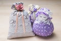 Scented sachets and pouch figure of a girl. Close up of bags filled with lavender on wooden table or board.
