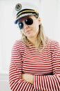 Sceptically young woman sailor in captain cap - wearing red gaps dress Royalty Free Stock Photo