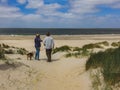 SCHARENDIJKE - NETHERLANDS -MAY, 17, 2018: active couple with dog walks in dunes of North Sea, Netherlands