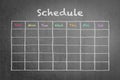 Schedule with grid timetable on black chalkboard