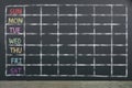 Schedule of the week with grid on black chalkboard background