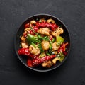 Schezwan Chicken or Dragon Chicken in black bowl at dark slate background