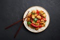 Schezwan Chicken or Dragon Chicken with basmati rice at black slate background