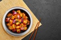 Schezwan Paneer in black bowl at dark slate background. Schezwan Paneer is indo-chinese cuisine dish