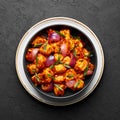 Schezwan Paneer in black bowl at dark slate background. Schezwan Paneer is indo-chinese cuisine dish Royalty Free Stock Photo