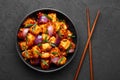 Schezwan Paneer in black bowl at dark slate background. Schezwan Paneer is indo-chinese cuisine dish