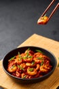 Schezwan Prawns in black bowl at dark slate background. Schezwan Prawns is indo-chinese cuisine curry dish