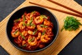 Schezwan Prawns in black bowl at dark slate background. Schezwan Prawns is indo-chinese cuisine curry dish