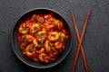 Schezwan Prawns in black bowl at dark slate background. Schezwan Prawns is indo-chinese cuisine curry dish