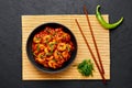 Schezwan Prawns in black bowl at dark slate background. Schezwan Prawns is indo-chinese cuisine curry dish