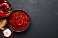 Schezwan Sauce in black bowl at dark background. Schezwan Sauce is Indo-chinese or Sichuan cuisine hot sauce with red chilli,