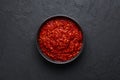 Schezwan Sauce in black bowl at dark background. Schezwan Sauce is Indo-chinese or Sichuan cuisine hot sauce with red chilli,