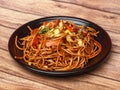 Schezwan Veg Noodles a popular indo-chinese dish made with noodles, vegetables and schezwan sauce, served over a rustic wooden Royalty Free Stock Photo