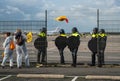 Police officers guarding the hole in the fence during protest action of climate activists from Extinction Rebellion and Greenpeace Royalty Free Stock Photo