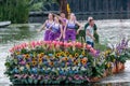 Colourful canal parade of flower and vegetables decorated boats with cheerful dressed up singing and dancing people