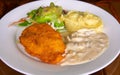 Schnitzel with mashed potato on white plate. Fried chicken cutlet top view photo on wooden table. Tasty lunch served