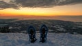 Schoeckl - A pair of snow shoes stuck into powder snow at the peak of Schoeckl in Austrian Alps, with the view on sun rising