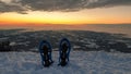 Schoeckl - A pair of snow shoes stuck into powder snow at the peak of Schoeckl in Austrian Alps, with the view on sun rising