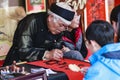 A scholar writes Chinese calligraphy characters at Temple of Literature