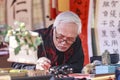 A scholar writes Chinese calligraphy characters at Temple of Literature