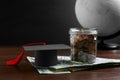 Scholarship concept. Graduation cap, money and globe on wooden table